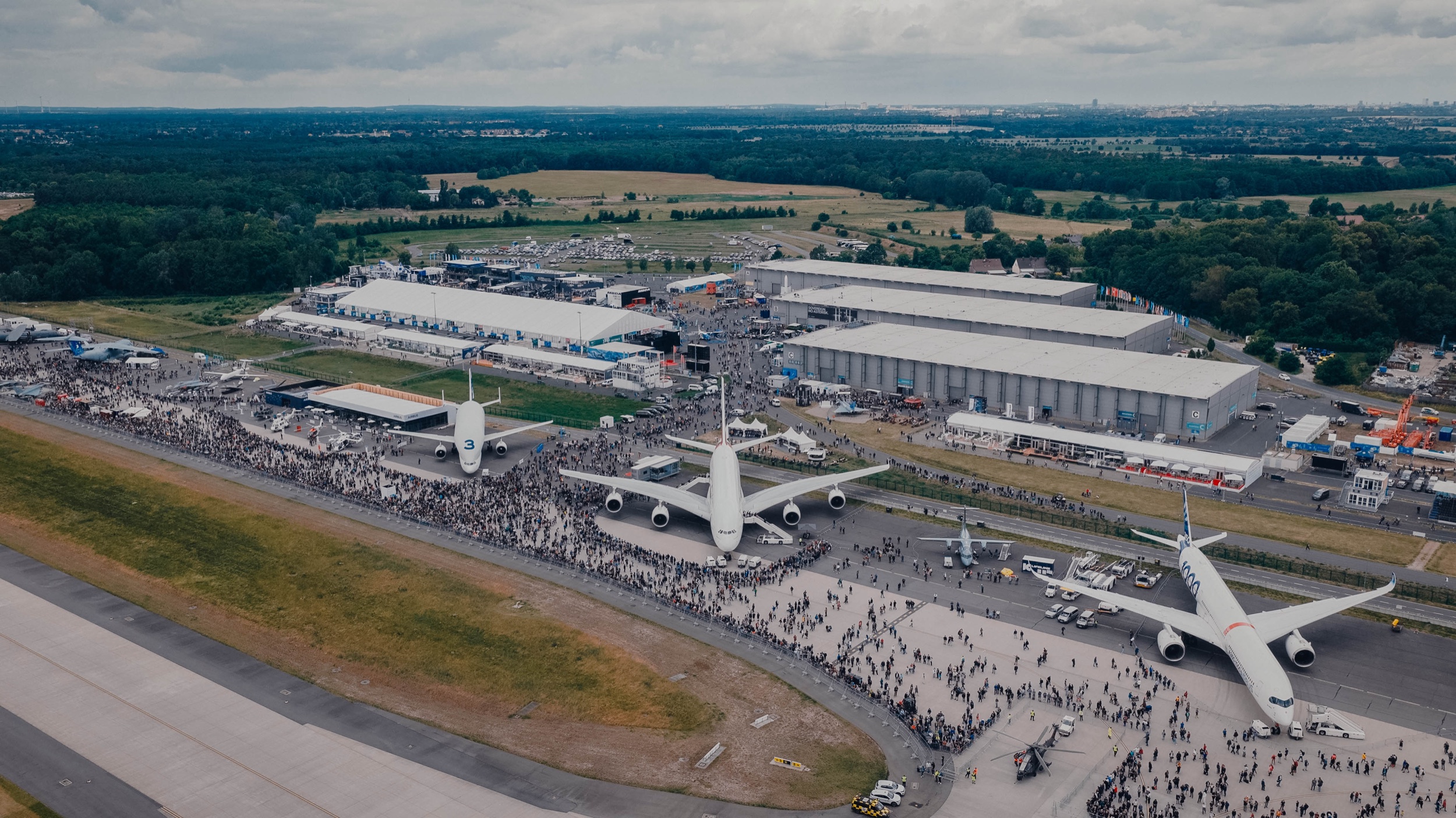 Aerial view of ILA Berlin 2026 with exhibition halls, large aircraft and visitor streams