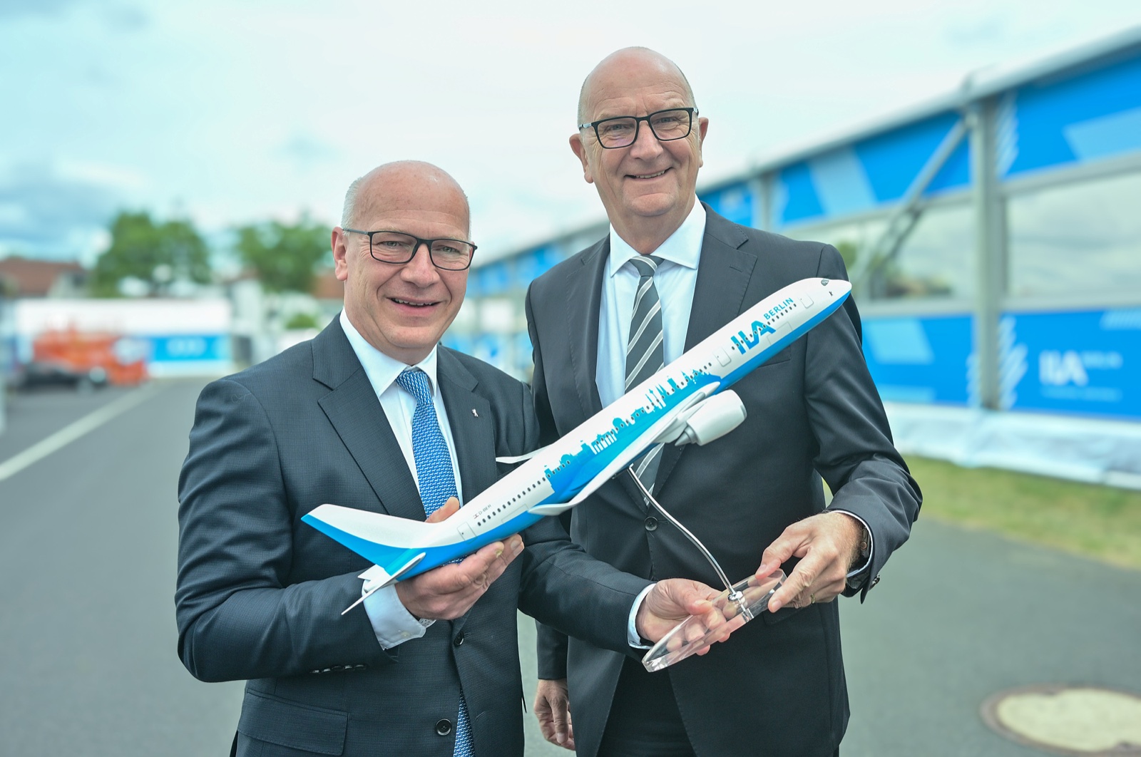 Berlin Governing Mayor Kai Wegner and Brandenburg Minister-President Dietmar Woidke holding an ILA aircraft model